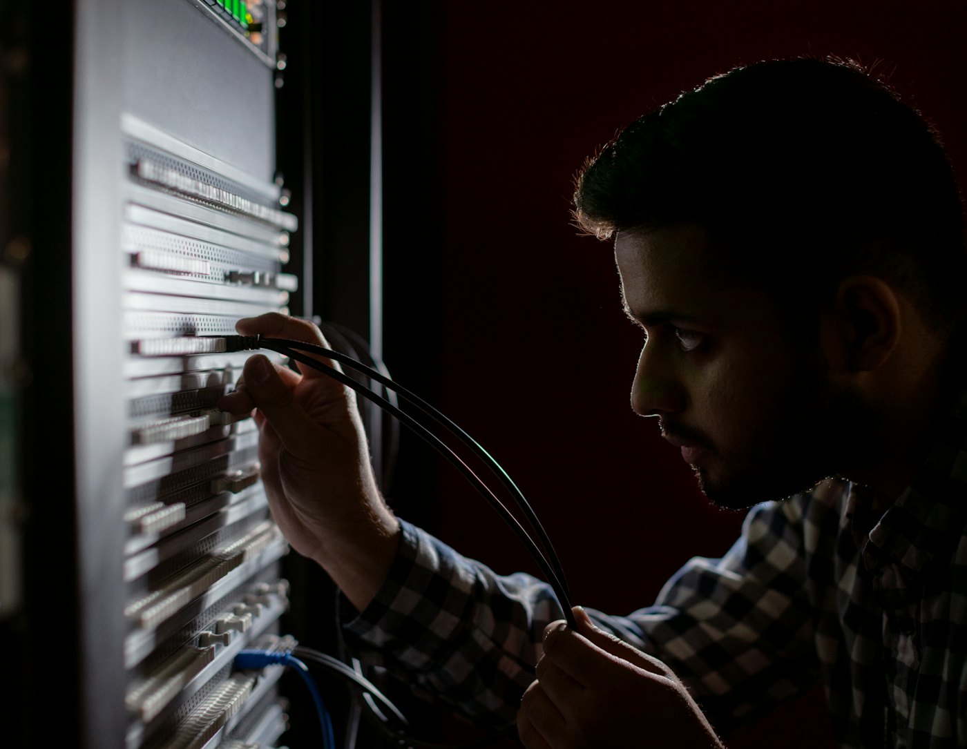 Technician connecting network cables in a server rack